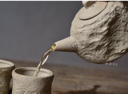 Un pot et deux tasses de céramique artisanale en grès et argile